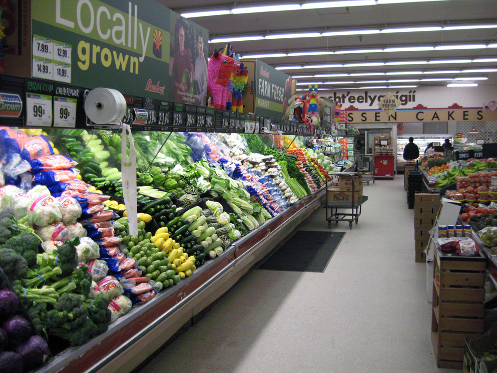 Grocery store produce aisle stocked with fresh vegetables